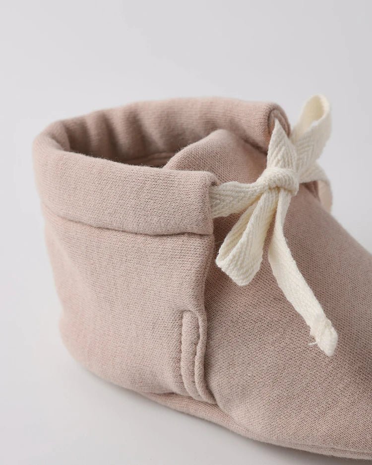 Beige fabric drawstring bag on a light gray background
