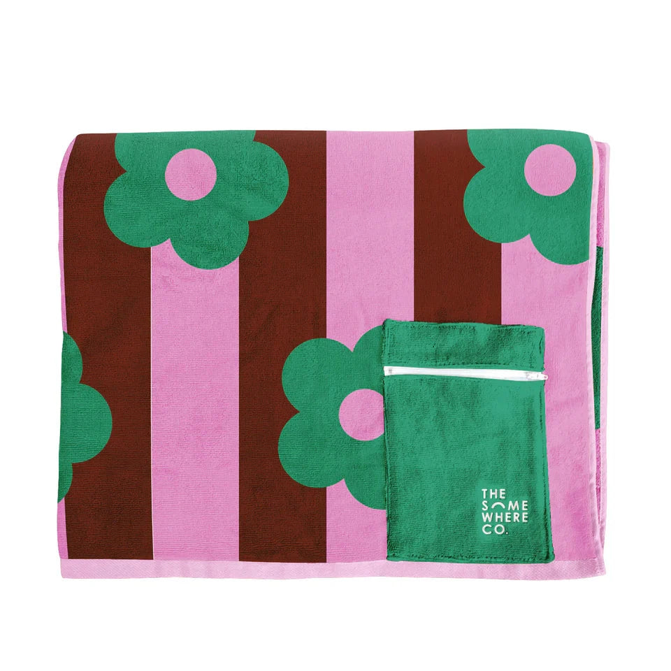 Folded towel with green floral patterns and pink stripes on a white background