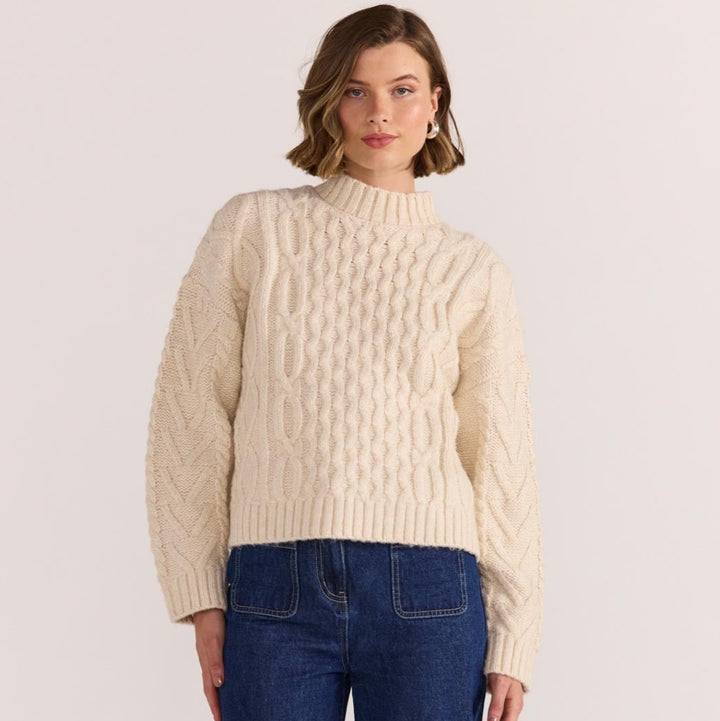 Chunky, cosy, and a cold-weather classic - the Rosina Cable Knit Jumper in cream is your go-to for elevated everyday warmth. Available from www.thecollectivenz.com