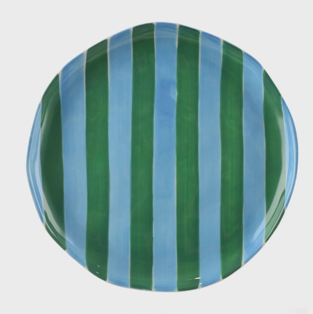 Green and blue striped ceramic plate on a white background