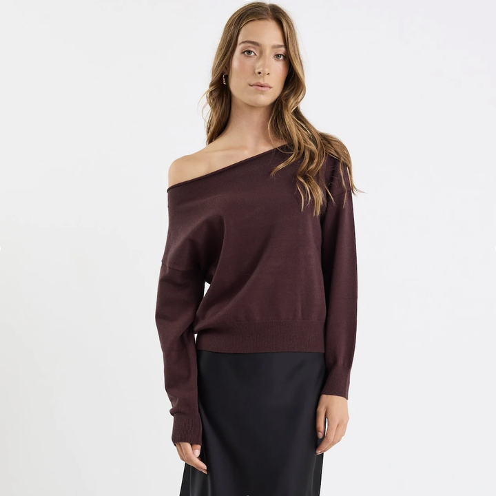 Woman wearing a brown off-shoulder sweater on a white background