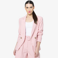 Woman wearing a pink seeking lola blazer on a white background