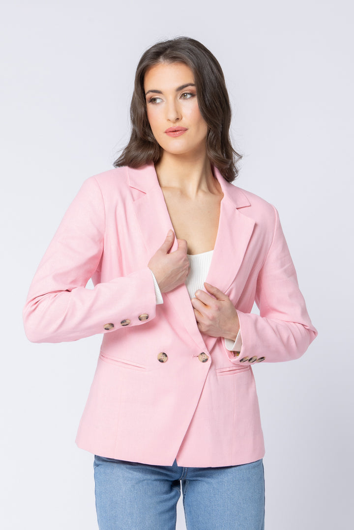 Woman wearing a pink blazer on a light gray background