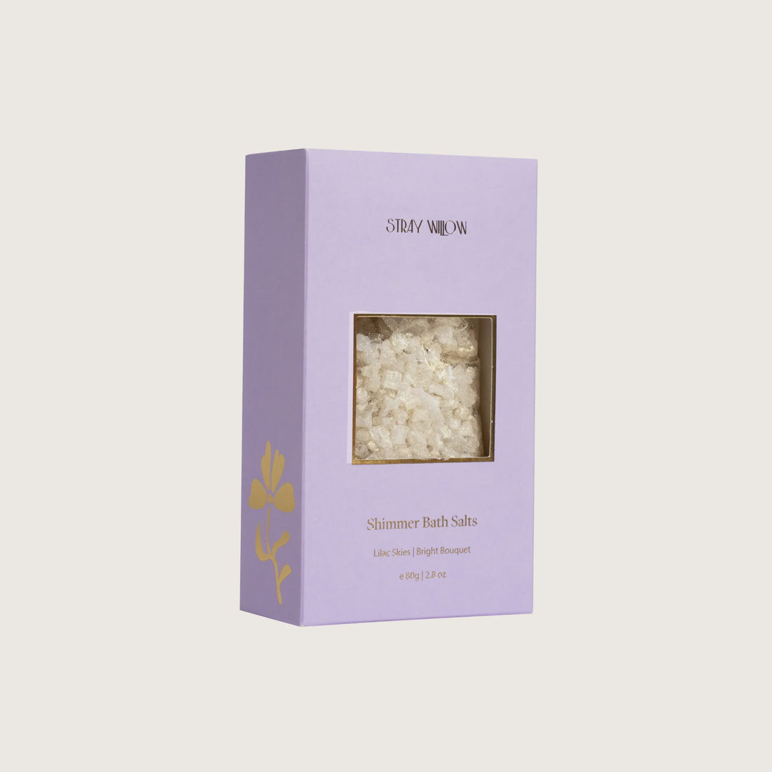 Purple box of Shimmer Bath Salts with visible contents on a light gray background