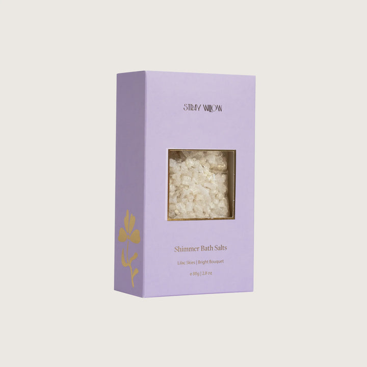 Purple box of Shimmer Bath Salts with visible contents on a light gray background