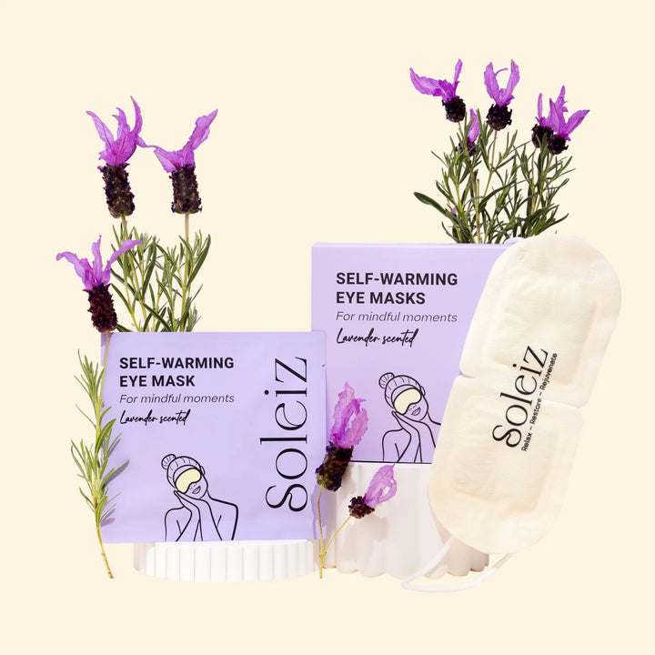 Soleiz self-warming eye masks with lavender scent packaging and lavender flowers on a beige background