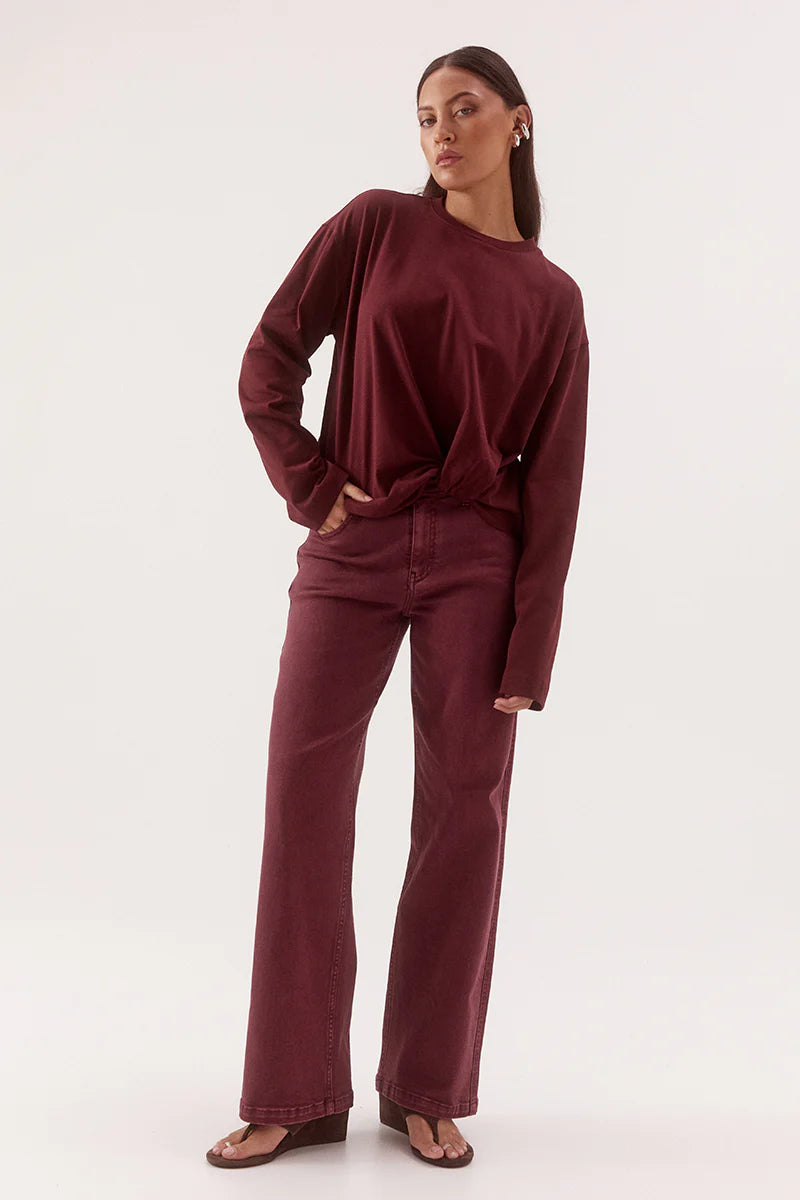 Woman wearing a burgundy outfit on a white background