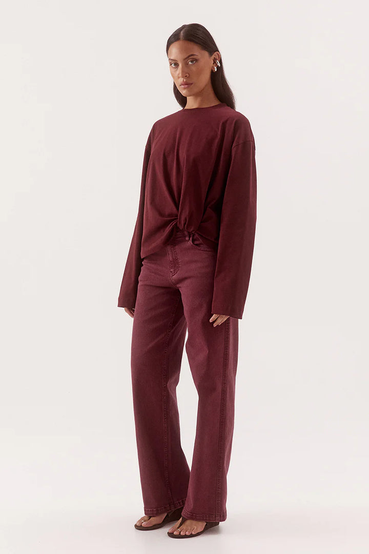 Woman wearing a burgundy outfit on a white background