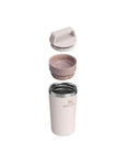 Pink insulated tumbler with multiple lids on a white background