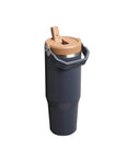 Navy blue insulated mug with a beige lid and wooden spout on a white background