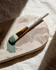 Paintbrush with green paint on a stone surface