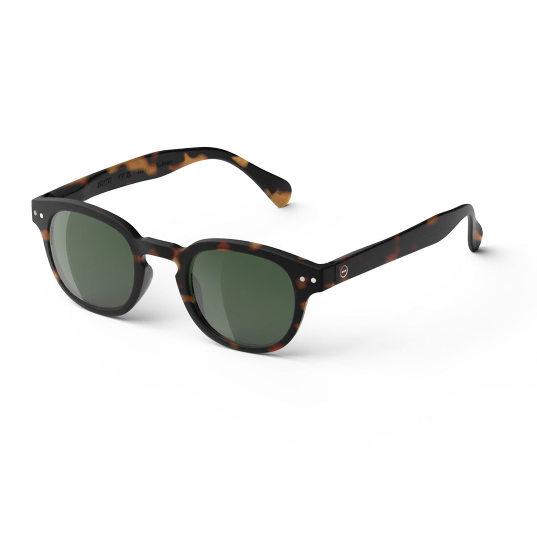 Sunglasses with tortoiseshell frame and green lenses on a white background