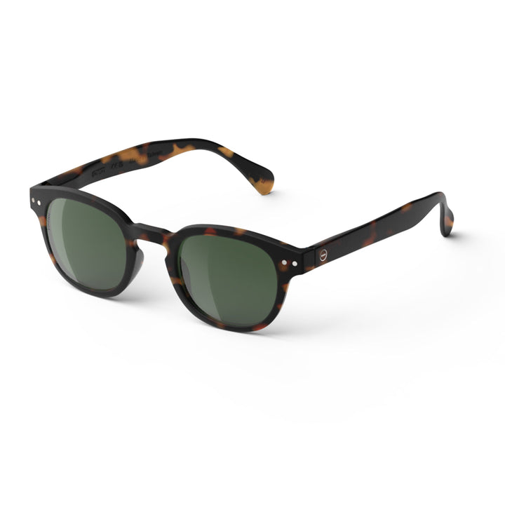 Sunglasses with tortoiseshell frame and green lenses on a white background