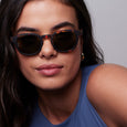 Woman wearing sunglasses with a neutral background