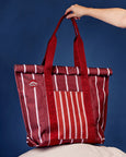 Red and white striped tote bag with visible branding against a blue background