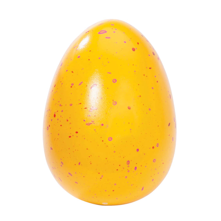Yellow egg-shaped object with pink speckles on a white background