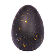 Black egg-shaped object with speckled pattern on a white background