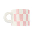 Checkered mug with pink and white pattern on a white background
