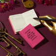 Pink diary titled 'A Tiny Diary for Not So Tiny Secrets' on a purple background with keys and flowers.