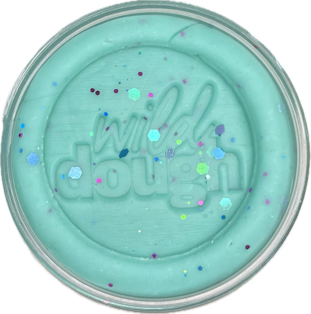 Turquoise-colored pot of 'wild dough' with colorful specks on a white background