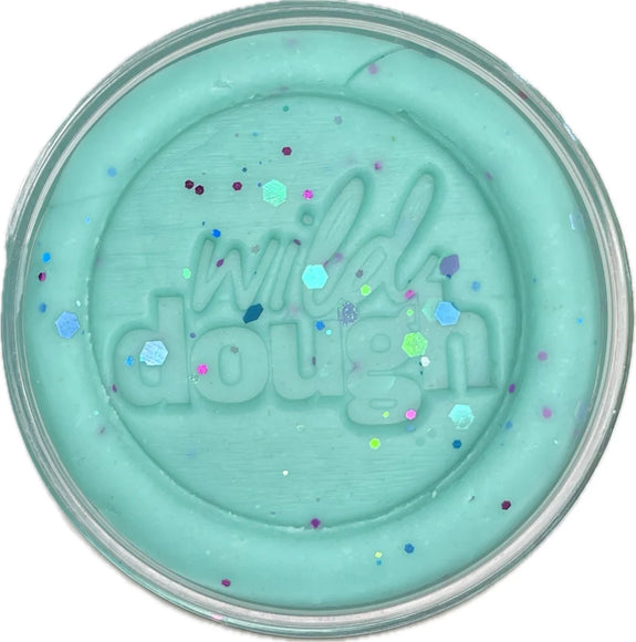 Turquoise-colored pot of 'wild dough' with colorful specks on a white background