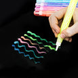 Colorful wavy lines drawn on black paper with a hand holding a yellow marker.