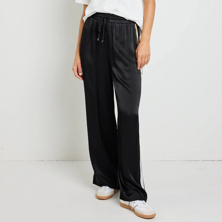 Woman wearing a white top and black pants on a white background