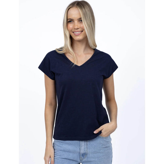 Woman wearing a navy blue t-shirt and light blue jeans on a white background