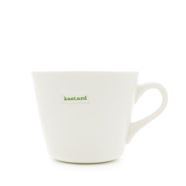 White mug with green text 'bastard' on a white background