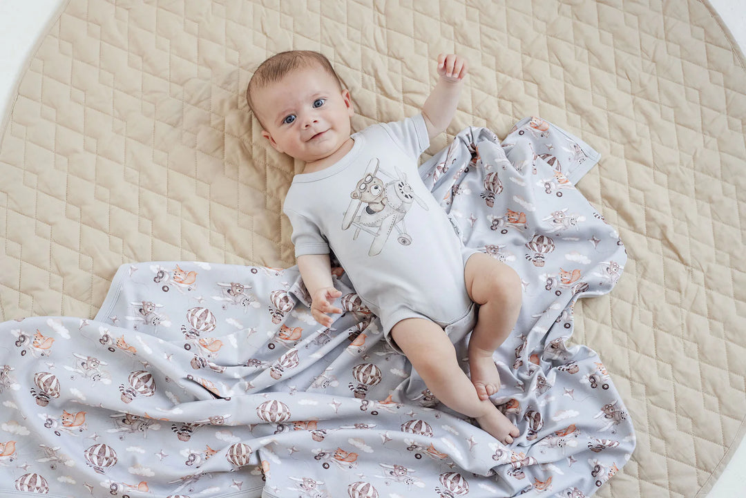 Baby lying on a floral blanket with a neutral background