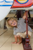 Child playing with a toy airplane indoors
