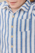 Close-up of a child wearing a blue and white striped shirt with buttons.