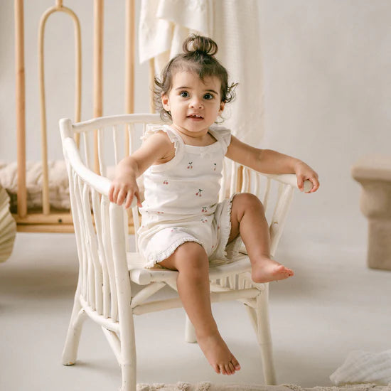 Child sitting on a white chair in a softly lit room