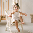 Child sitting on a white chair in a softly lit room
