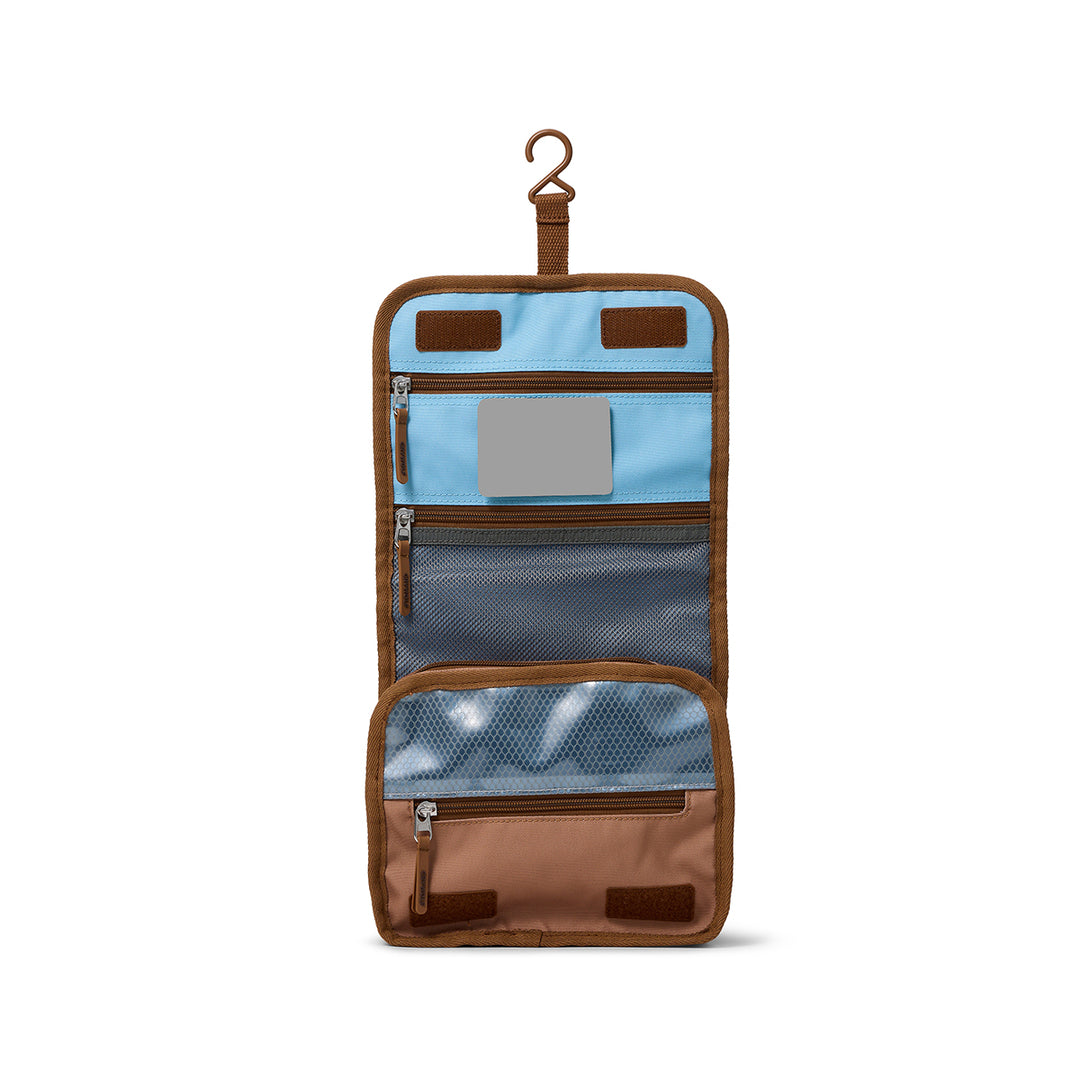 Brown travel toiletry bag with blue interior on a white background