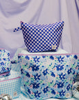 Set of blue and white checkered bags with floral patterns on a light purple background