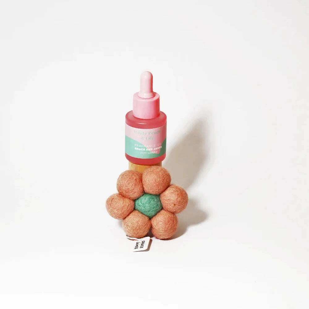 Bottle with pink dropper and colorful balls on a white background