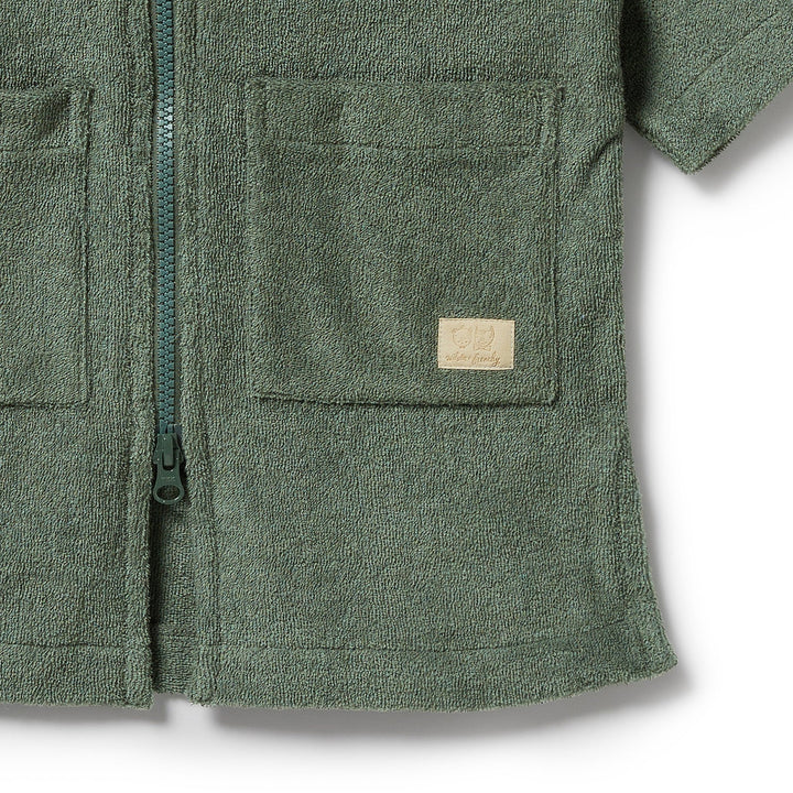 Green fleece towel with a pocket and zipper detail on a white background