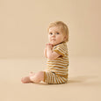 Baby wearing a wilson & frenchy yellow and white striped outfit on a beige background