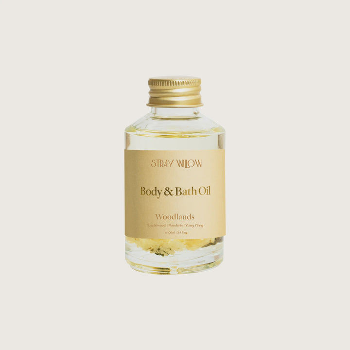 Body and bath oil bottle labeled 'Woodlands' on a white background