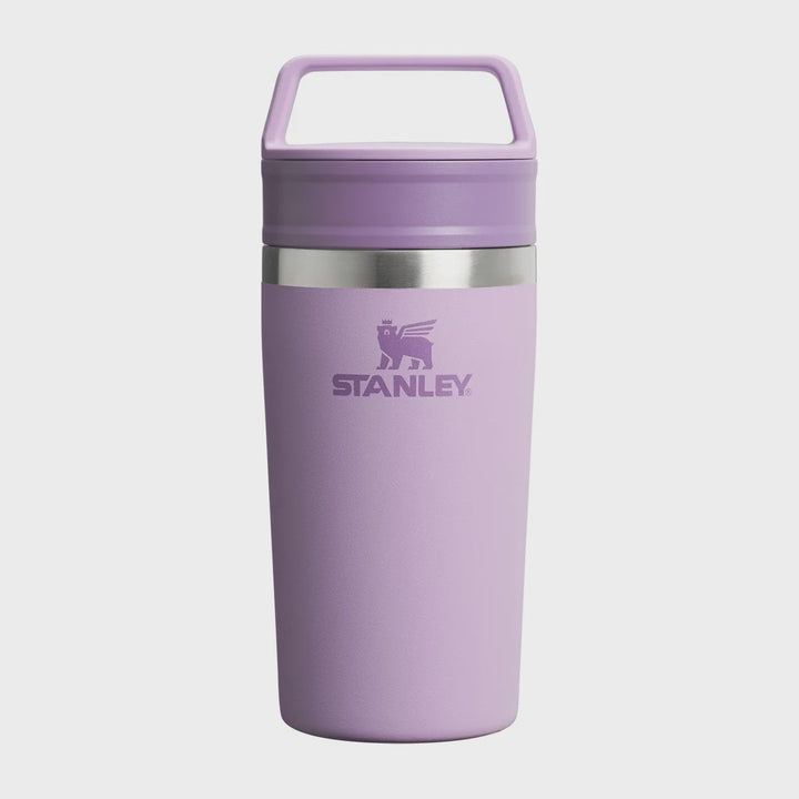 A lavender purple Stanley travel tumbler with a matching lid and carry handle, featuring a silver metallic band and the Stanley logo on the front, set against a light gray background.