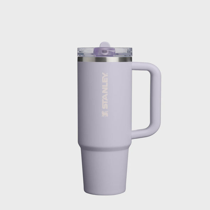 Purple Stanley tumbler with handle on a white background