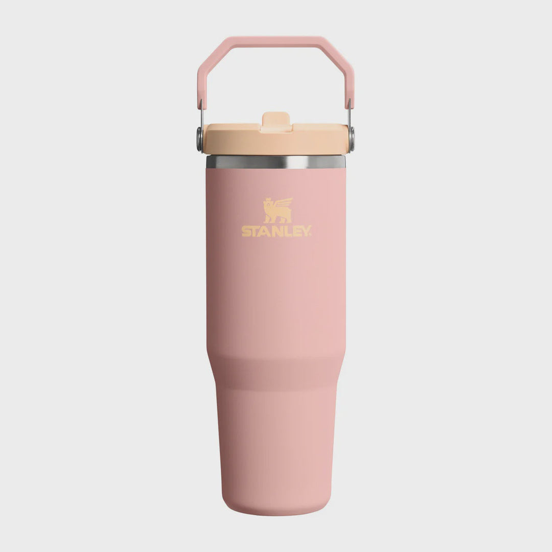 Pink Stanley tumbler with a beige lid on a white background