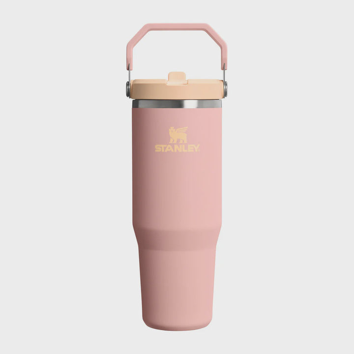 Pink Stanley tumbler with a beige lid on a white background