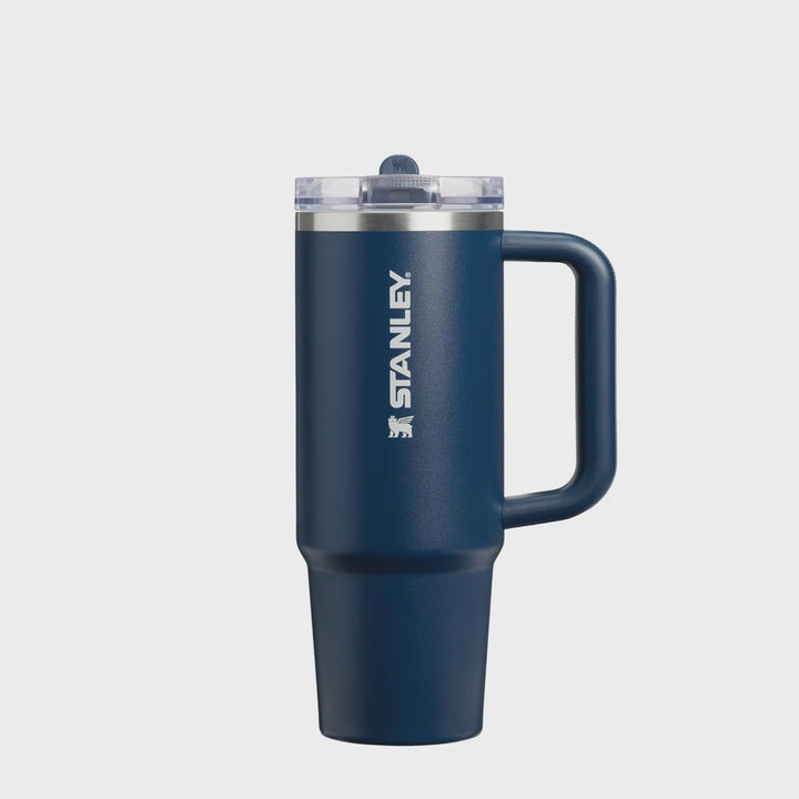 A navy blue Stanley travel mug with a handle, clear lid, and white Stanley logo on the side, shown against a plain white background.