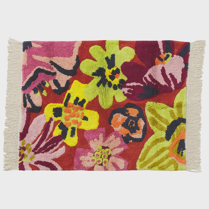 Colorful floral-patterned rug with fringe on a white background