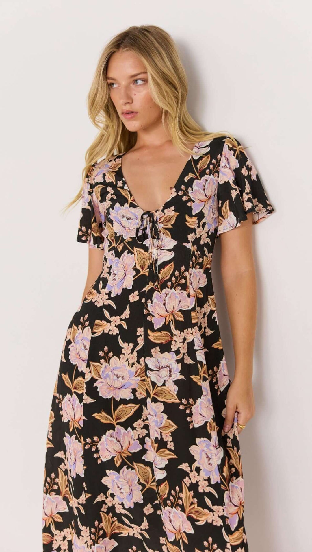 The Willow Midi Dress features a bold floral print on a soft, lightweight fabric that moves with you. With flutter sleeves and a relaxed tie-front detail, it’s the ultimate day-to-night piece. Available from www.thecollectivenz.com