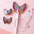 Butterfly-shaped hair clips with glittery finish on a pink background