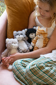 Child sitting on a couch with a collection of stuffed animals