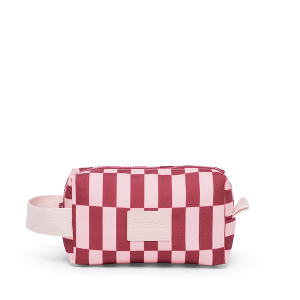 Pink and red checkered bag with a strap on a white background